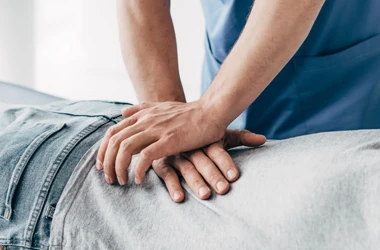 A chiropractor delivering an adjustment to a patient's back
